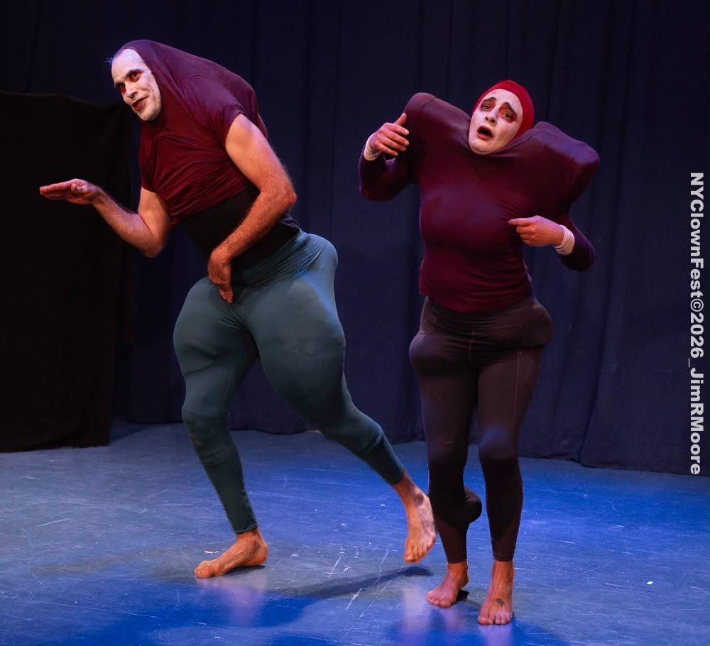 The two bouffons strut in step across a blue-lit stage.