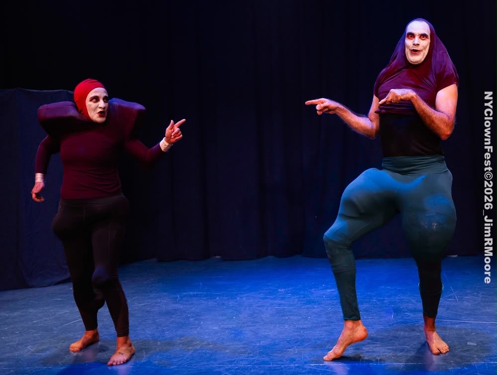 The two performers point at each other across the stage.
